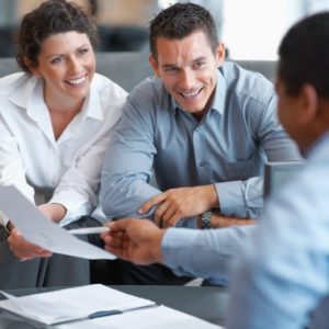 Couple looking at insurance forms with Insurance Broker