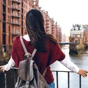 Lady in a red jumper looking across a river