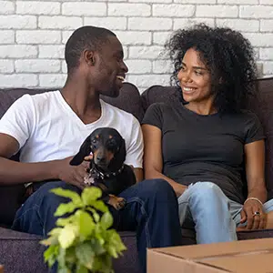 Happy couple in their new home with their dog