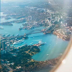 An aerial view from an aeroplane window over Sydney’s harbour and green spaces