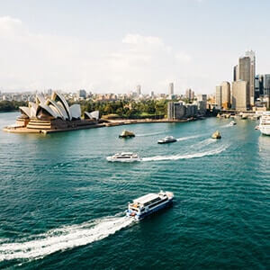 Boats moving around Sydney’s Harbour with a view of the city skyline and Opera House..png