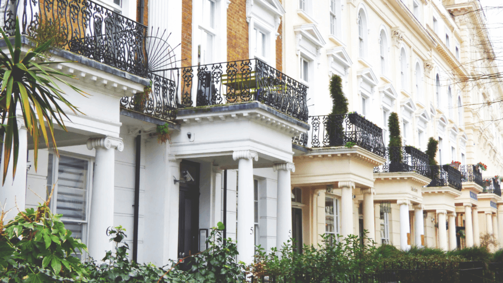 Ornate white buildings with iron fencing around balconies in a London street