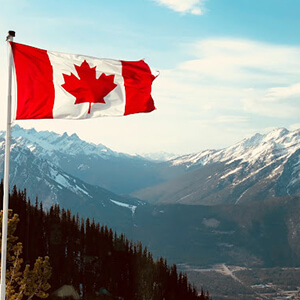 Canadian flag displayed against the Rocky Mountains