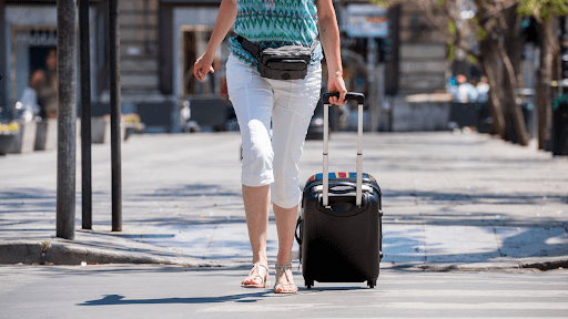 Lady walking out of the airport with her suitcase