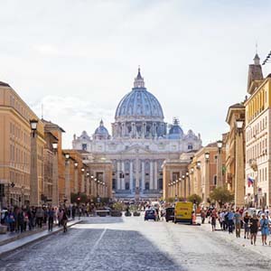 Looking across a cobbled square in Vatican City, Rome, opposite the Vatican’s dome