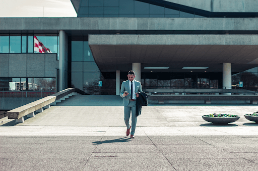 Man walking out of large buisness building