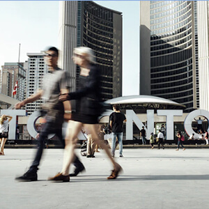 People walking in front of Toronto sign