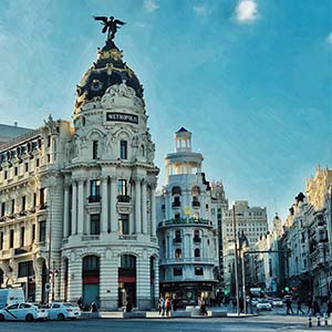 The white building of the Metropolis in Madrid, Spain, with a blue sky in the background