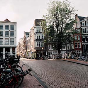 View of a cobbled street in Amsterdam with bicycles lining the fences