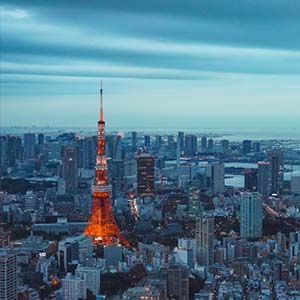 Aerial view of Tokyo city with the Tokyo tower lit up in red among grey buildings