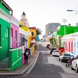 Colourfully painted buildings with parked cars along a street in Cape Town