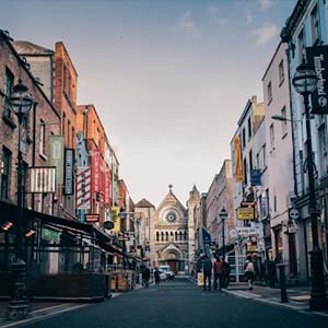 Shot of Anne Street, Dublin, with a grand church building and colourful signs