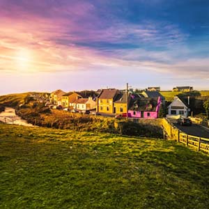 Sunset over a rural Irish dwelling surrounded by green fields and fences