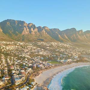 The coast of Cape Town at Camps Bay with a row of small mountains in the background