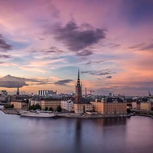 View over Stockholm from the harbour’s water with the sun setting in the sky