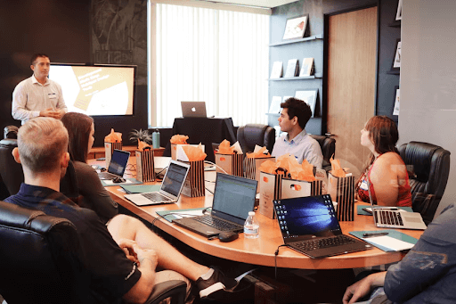 Group Of Employees Sitting Around A Conference Table