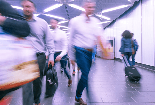 People Walking Quickly Through An Airport Terminal
