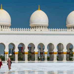 Two women walking in front of the Sheik Zayed Grand Mosque in Abu Dhabi, UAE