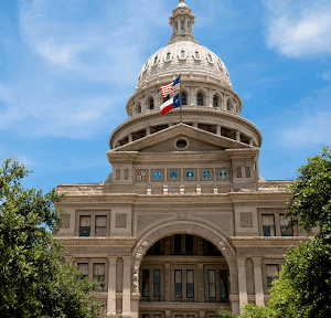 Capitol in Austin Texas, a monumental building with the Texas and USA flag