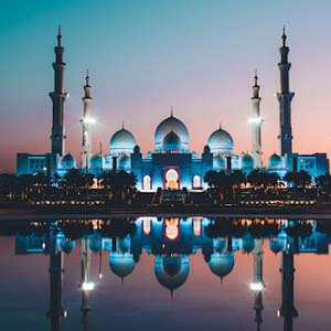 Huge temple in Dubai lit up against a pink and blue sky
