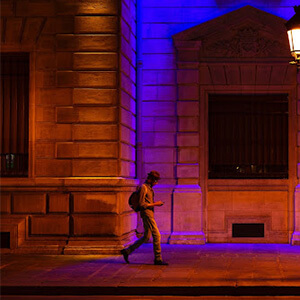 Man walking through the streets of Paris at night