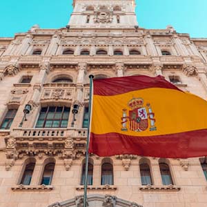 Spanish flag flying on side of a building in Madrid