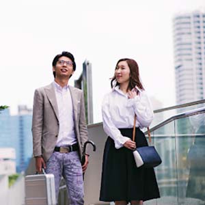 Japanese corporate staff walking beside glass office buildings