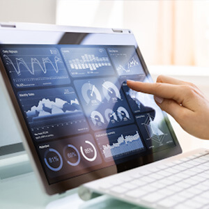 Hand reaching for a screen showing a variety of reporting metrics