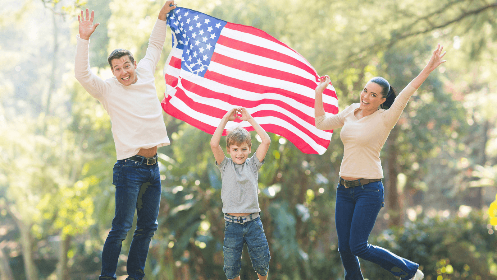 Cheerful Family Jumping While Holding The USA Flag