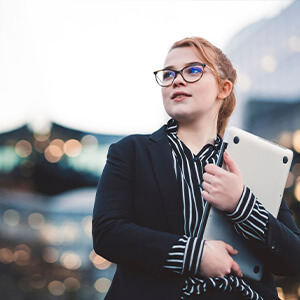 Close-up shot of a female worker with blurred office buildings in the background