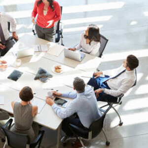 Group of employees sitting around an office table Group of employees sitting around an office table